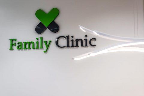 logo przychodni Family Clinic Warszawa na białej ścianie